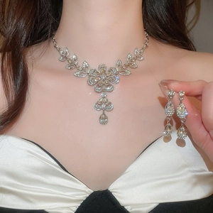 Elegant floral rhinestone necklace and earring set shown on model in silver tone finish