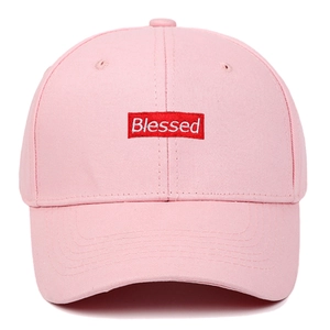 Pink cotton baseball cap featuring a curved brim and red Blessed embroidered patch