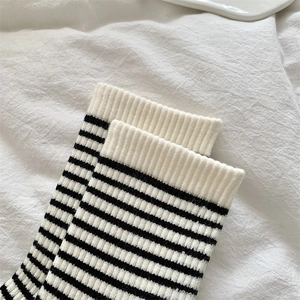 Detailed macro shot of the black and white striped knitted texture on warm wool socks