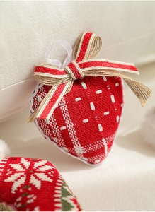 Detail of red fabric heart ornament with white embroidery, lace trim and jute rope bow