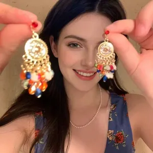 Close-up of bohemian tassel earrings with colorful beads and hollow metal discs