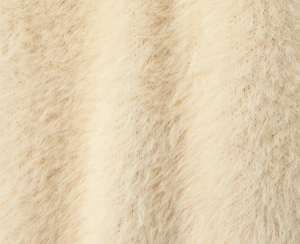 Detailed close-up of soft beige mohair fabric texture on a long hooded cardigan