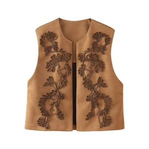 Detail of camel brown suede vest featuring 3D floral embroidery and premium stitching