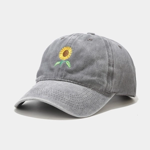 Detail of sunflower embroidery on gray washed cotton baseball cap with high texture