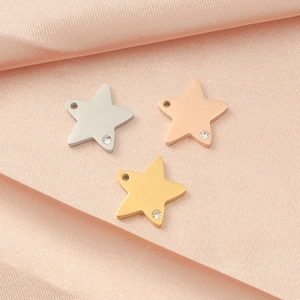 Polished star pendants in silver, rose gold, and gold with sparkling stones on pink silk