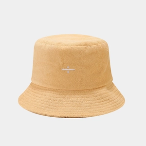 Detail of warm yellow terry cloth bucket hat with minimalist white embroidery