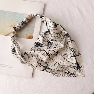 Detailed view of black and white patterned chiffon head scarf with elastic band detail