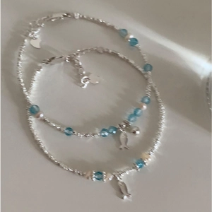 Ethnic silver-beaded pearl bracelet with blue beads and a small fish pendant charm