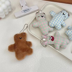 Detailed view of cute plush bear and rabbit keychains with colorful plaid patterns