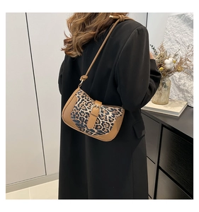 Close-up of leopard print shoulder bag with brown faux leather trim and metallic buckle