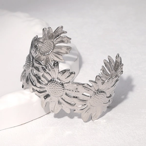 Polished silver stainless steel wide cuff bracelet with sunflower design on stone stand
