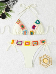 Flat lay of cream bikini with bohemian colorful crochet trim and summer accessories