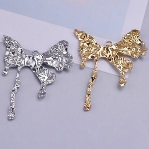 Macro detail of liquid metal butterfly pendants in gold and silver steel finish