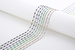 Detailed close-up of metallic mask chains with colorful round beads on a white background