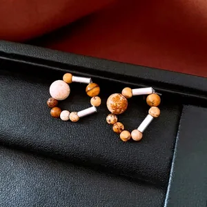 Minimalist silver earrings with mixed natural stone beads on black leather display