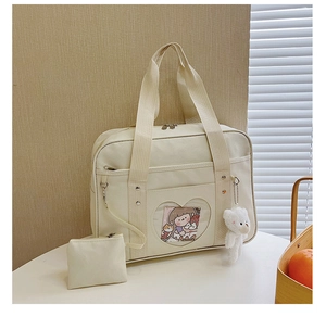 Detail of cream white JK Ita bag with heart transparent window and plush bear charm