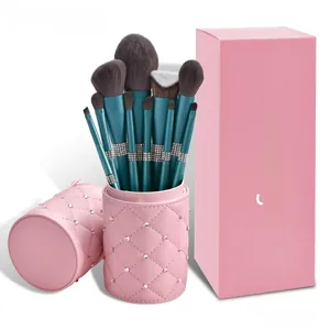 Green makeup brushes with rhinestone details in a pink quilted faux leather holder