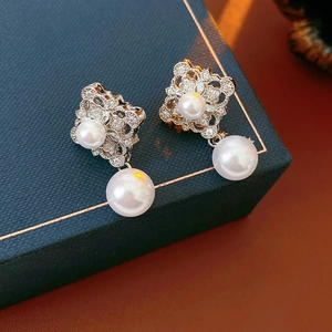 Detailed close-up of vintage lace floral earrings with white pearls and sparkling zircons