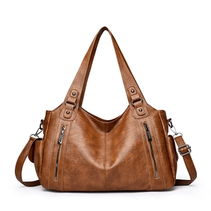 Vintage brown leather tote bag with stylish rivet details and multiple zippers