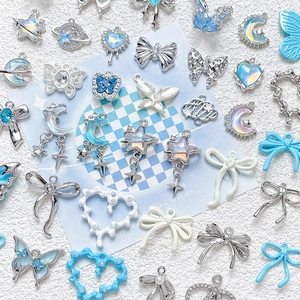 Close-up of DIY jewelry pendants featuring blue and silver hearts, stars, and butterflies