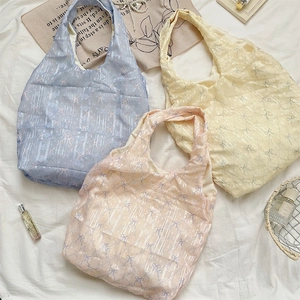 Détail de sacs fourre-tout d'été avec imprimés nœuds et textures de dentelle verticale