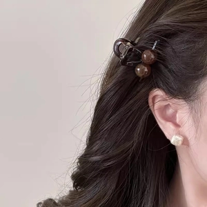 Close-up of a tortoiseshell hair claw clip styled on a woman's dark hair