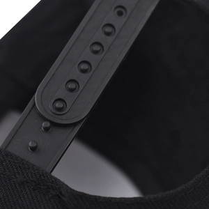 Macro shot of black snapback hat with adjustable plastic strap and cotton fabric