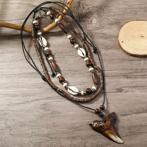 Detailed close-up of multilayer ocean necklace featuring shell and shark tooth charms