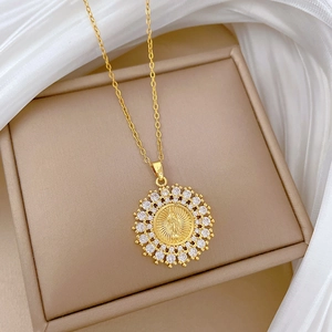 Detail of gold circular medallion necklace with virgin mary relief and sparkling diamonds
