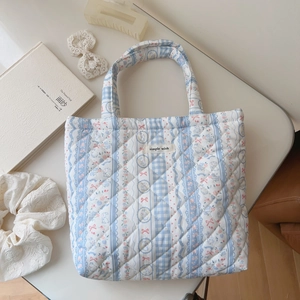 Detailed view of quilted cotton handbag with floral patterns and a small bunny print