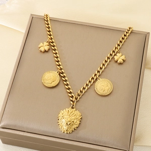 Detail of golden Cuban chain necklace featuring lion head, coin, and flower charms