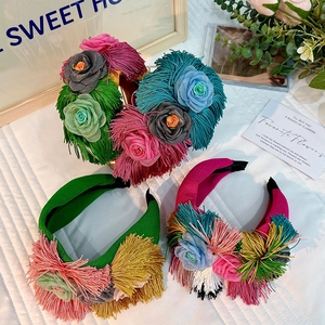 Flat lay of colorful floral fabric headbands with long fringes on a white quilted background