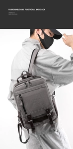 Detail view of the gray canvas backpack with multiple pockets and adjustable buckles