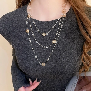 Detail of elegant three-layer gold chain necklace with champagne crystal beads