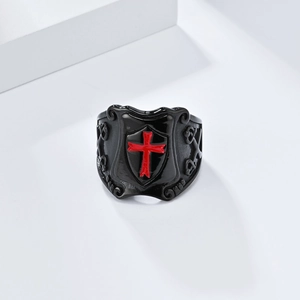 Close-up of black punk shield ring featuring a medieval red knight cross design