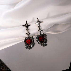 Dark red heart earrings with silver needle, black metal star accents on silk background