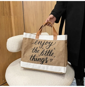 Dettaglio della borsa tote in juta con stampa enjoy the little things e manici in cuoio