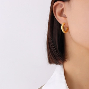 Polished 18K gold plated C-shaped hoop earrings for women on model side view