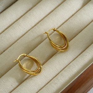 18k gold plated multi-layer U-shaped stainless steel earrings on a beige velvet jewelry box