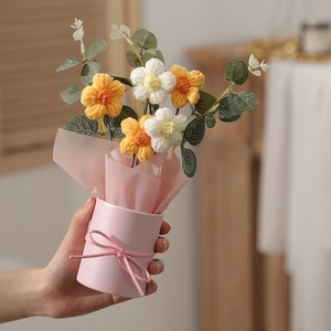 Detail of handmade crochet flower bouquet in pink bucket with yellow and white yarn petals