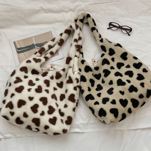 Flat lay of cream and yellow heart pattern plush tote bags with magazine and glasses