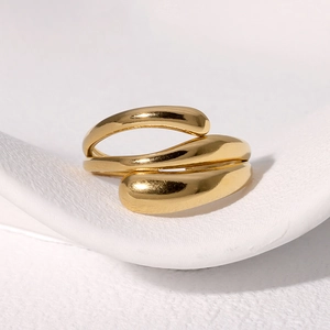 Detail of minimalist gold-plated multi-layer wrap ring with polished metallic finish