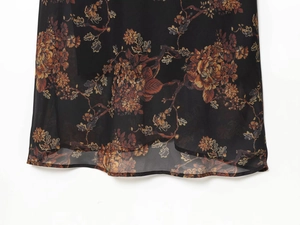 Detail von Vintage-Blumendruck auf leichtem, durchscheinendem schwarzem Chiffon-Saum
