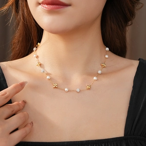 Detail of gold-plated flower necklace with zircon and pearl on model neck
