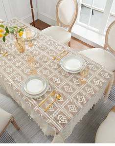 Detail of beige lace tablecloth featuring geometric woven texture and hollowed-out pattern