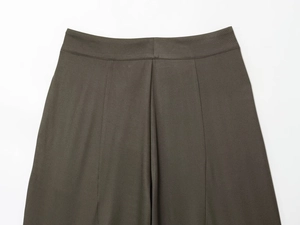 Detaillierte Makroansicht von dunkelolivfarbenem Twill-Gewebe auf Bundfaltenhosen