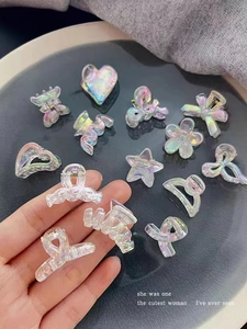 Detail of mini iridescent resin hair clips in heart and butterfly shapes with laser finish