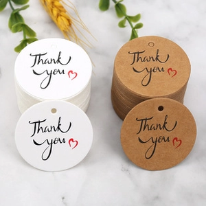 Macro view of round Thank You gift tags in white and kraft paper with red heart icon
