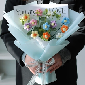 Handcrafted colorful crochet flower bouquet wrapped in blue paper with ribbon detail
