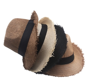 Macro shot of multi-color straw hats with frayed edges and black ribbon decoration